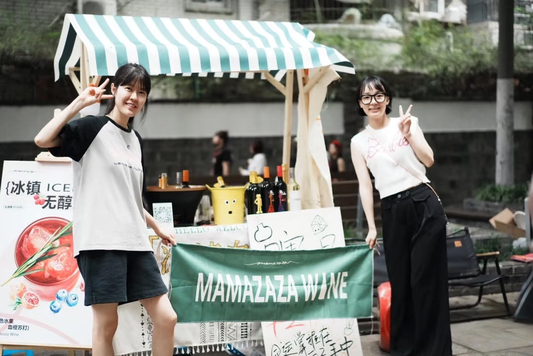 火烧堰市集饮品摊位前,两位摊主向镜头比出手势